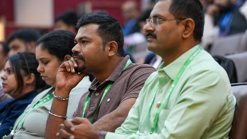 Participants attending a session, wearing conference lanyards