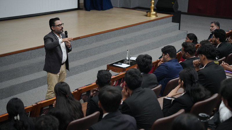 A speaker addressing students in a lecture hall