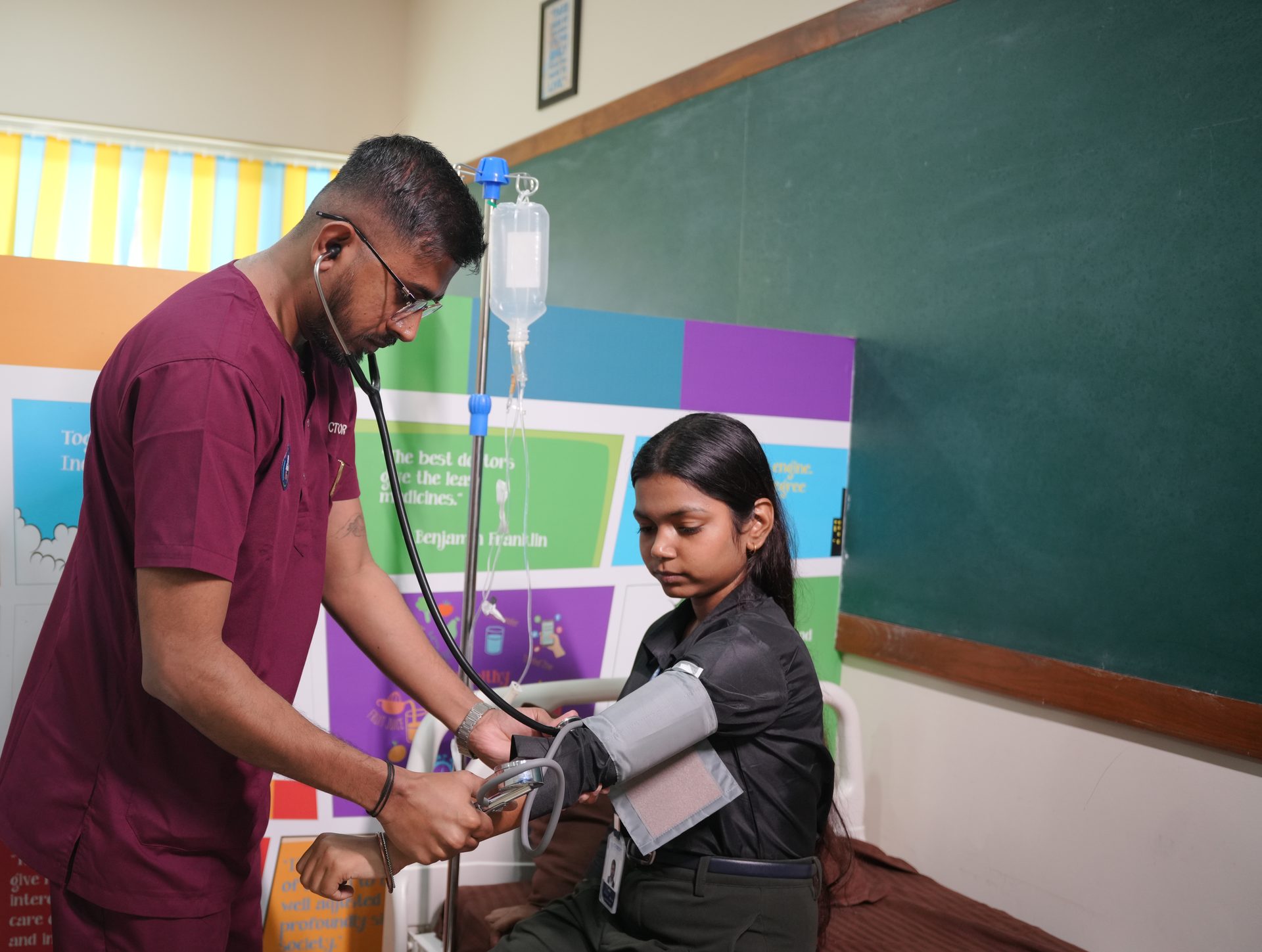 A doctor checking a student's blood pressure in the ward at the Apollo SHINE health room, CHRIST Lavasa